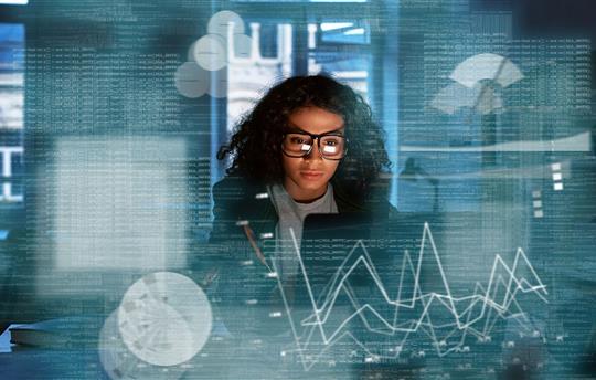 Young woman looking at computer screen, surrounded by visuals of statistics